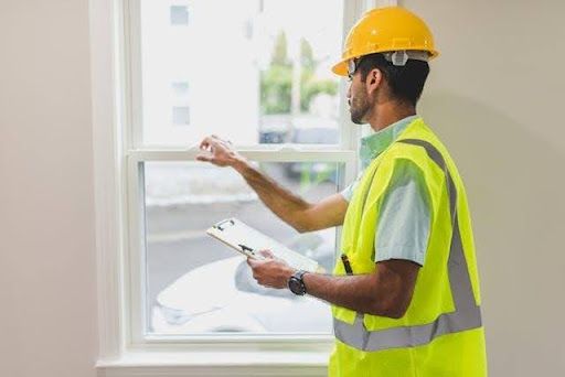 Construction inspector checking residential windows and home exterior during a property inspection s