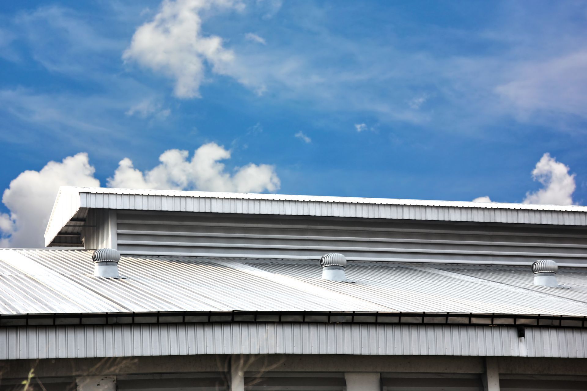 A white roof of a building with a blue sky in the background.