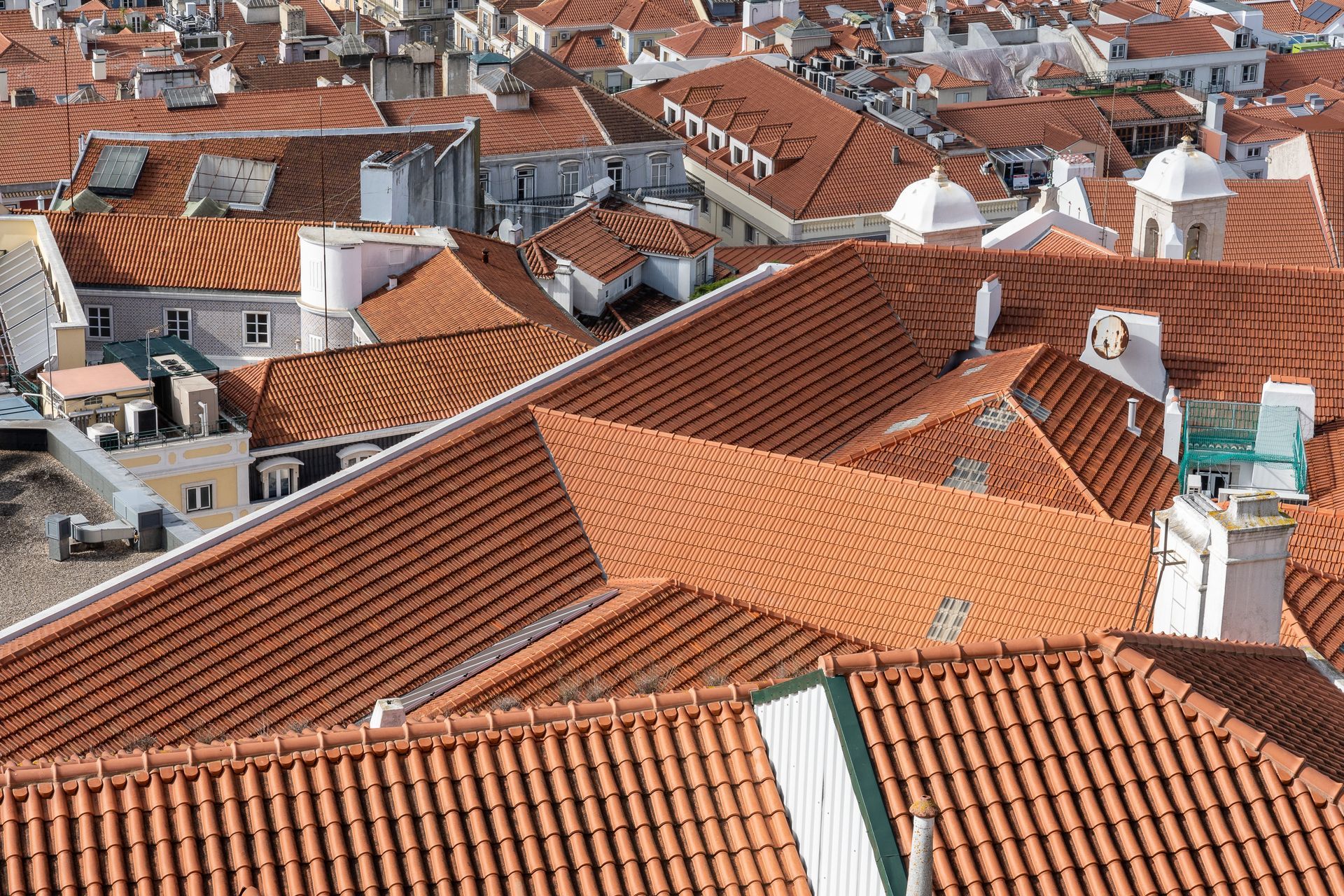 An aerial view of a city with lots of red tiled roofs