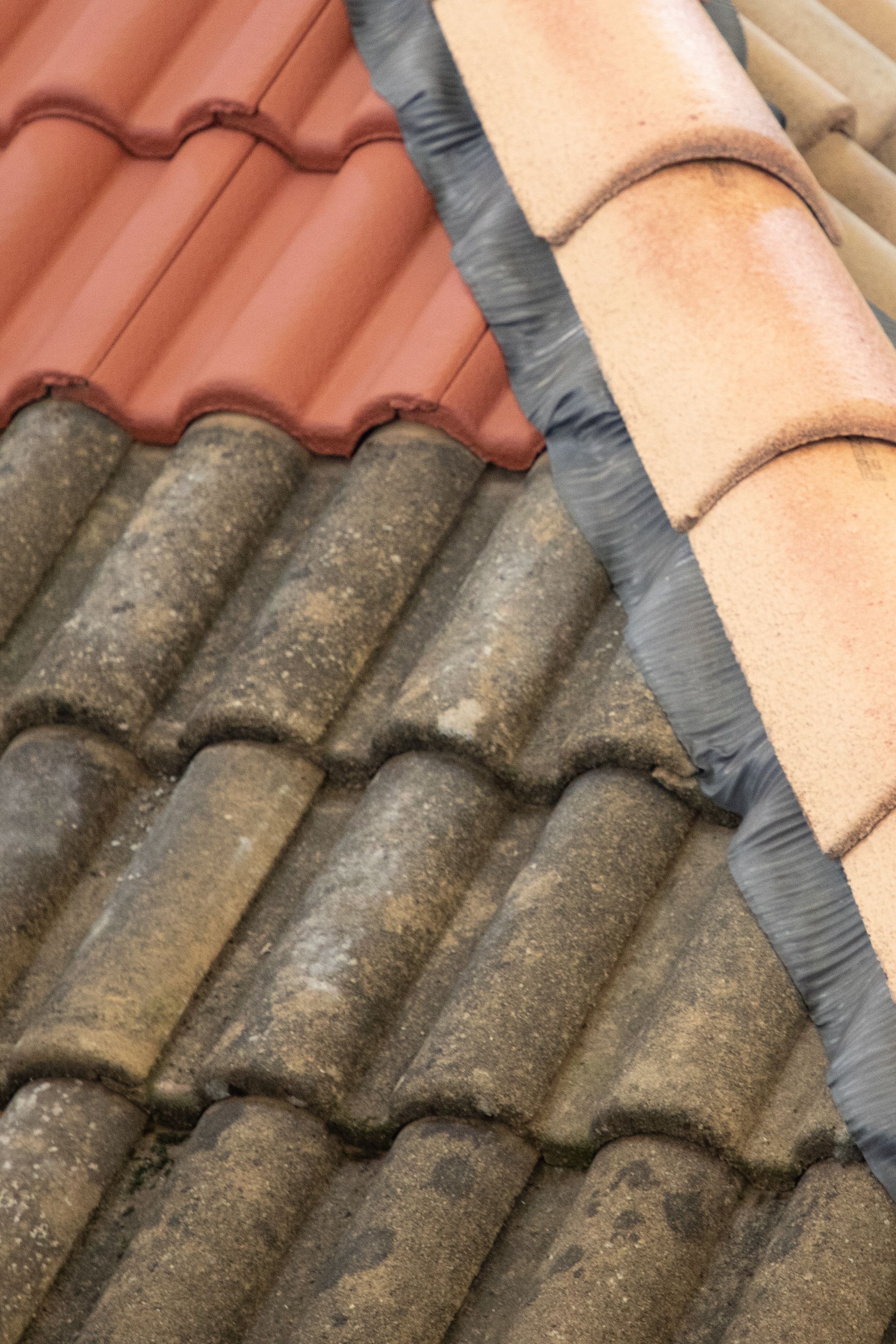 A close up of a tiled roof with a red roof in the background