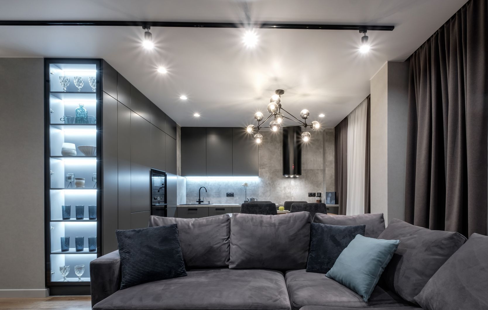 A living room with a couch and a kitchen in the background.