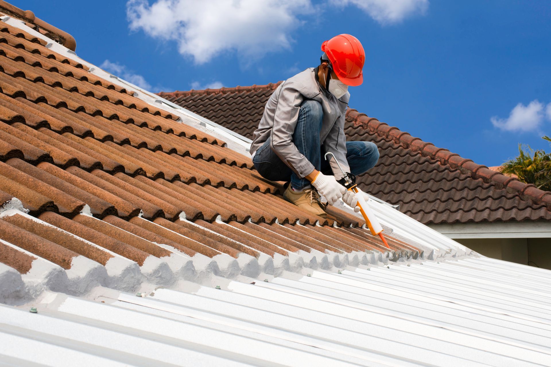 A man is painting the roof of a house.