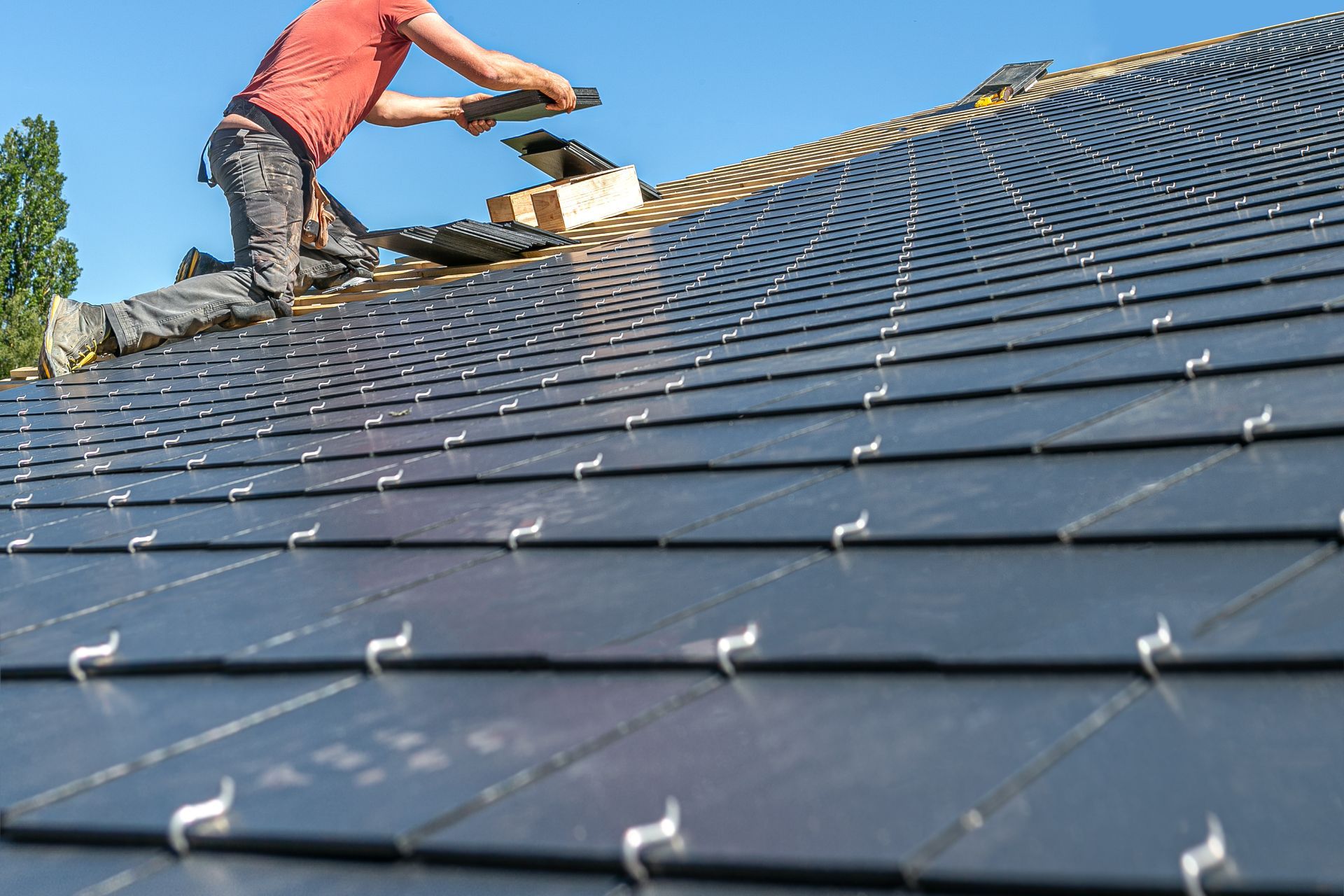 A man is working on the roof of a house.