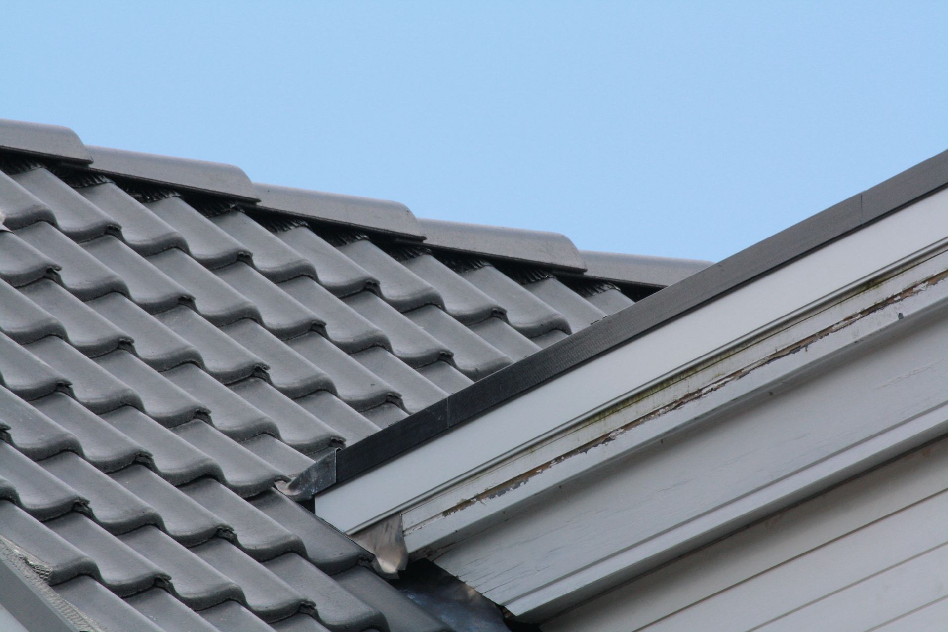 A close up of a roof with a blue sky in the background