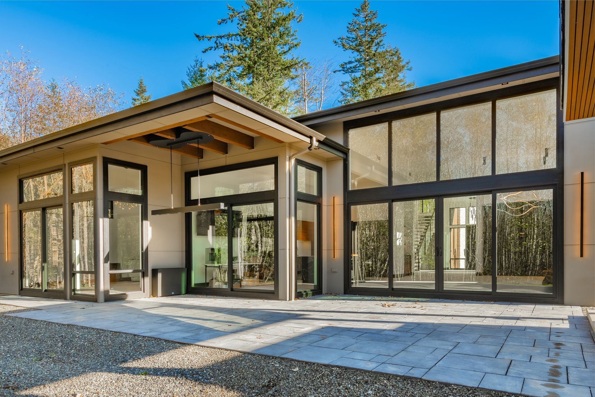 A modern house with a lot of windows and a driveway.