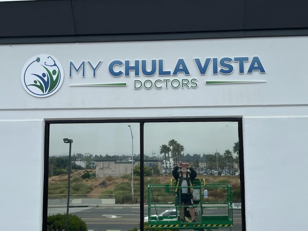 A sign for my chula vista doctors is being installed on the side of a building.