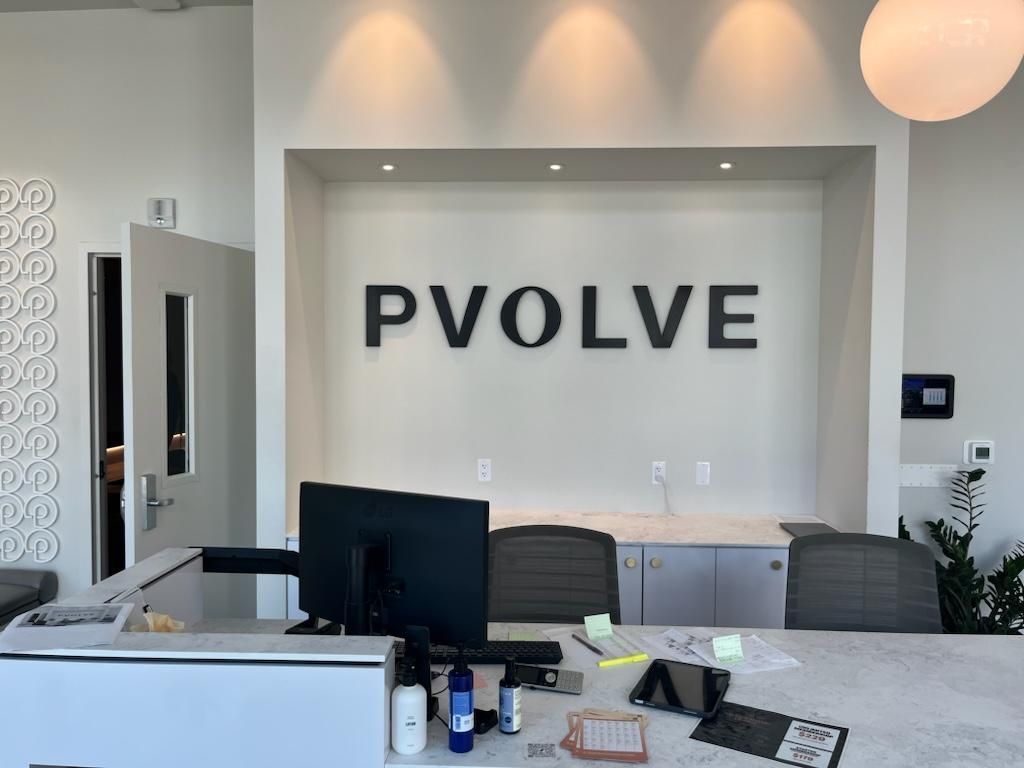 A reception area with a sign that says pvolve on the wall.
