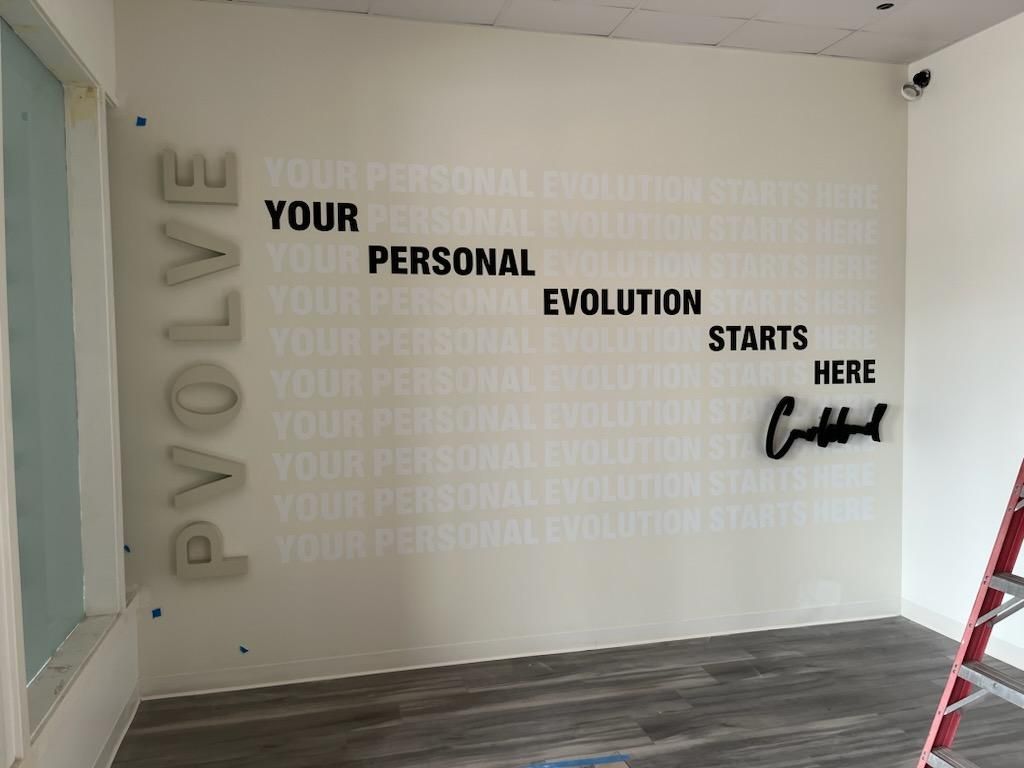 A room with a sign on the wall that says evolve your personal evolution starts here