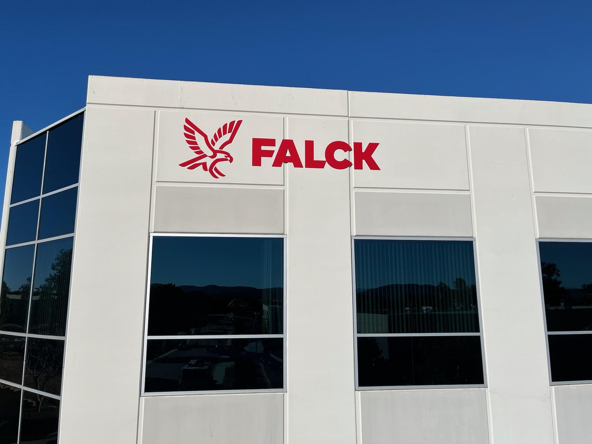 A white building with a red falck logo on it