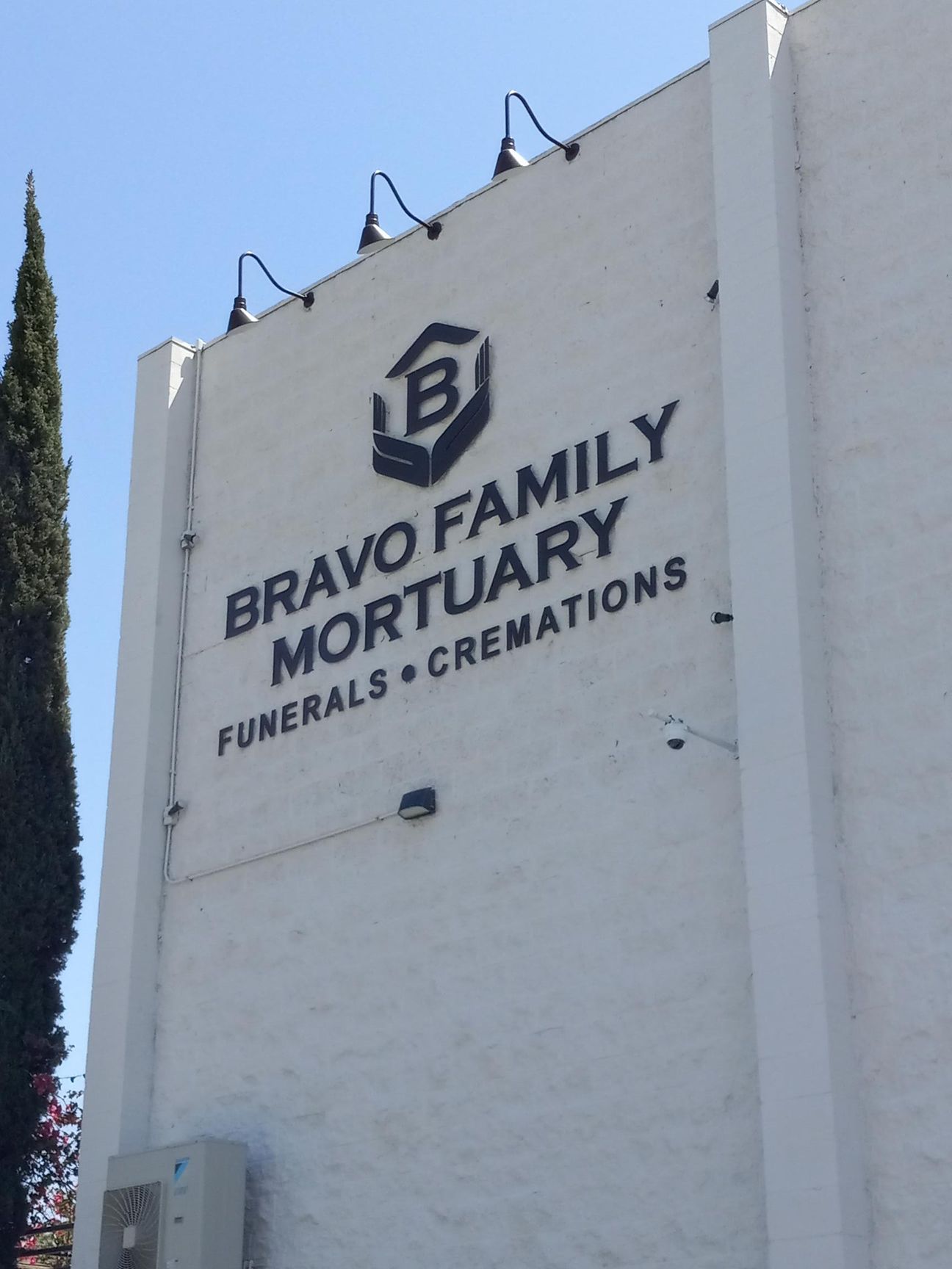 A white building with a sign that says bravo family mortuary funerals cremations
