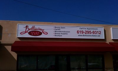 The front of a beauty salon with a red awning