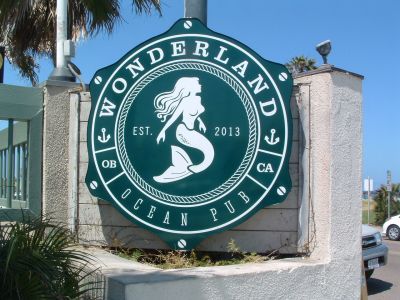 A green and white sign for wonderland ocean pub