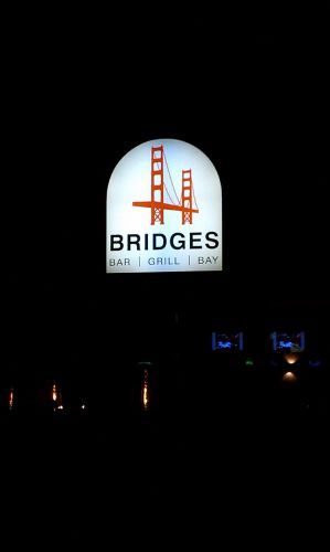 A bridges restaurant sign is lit up at night