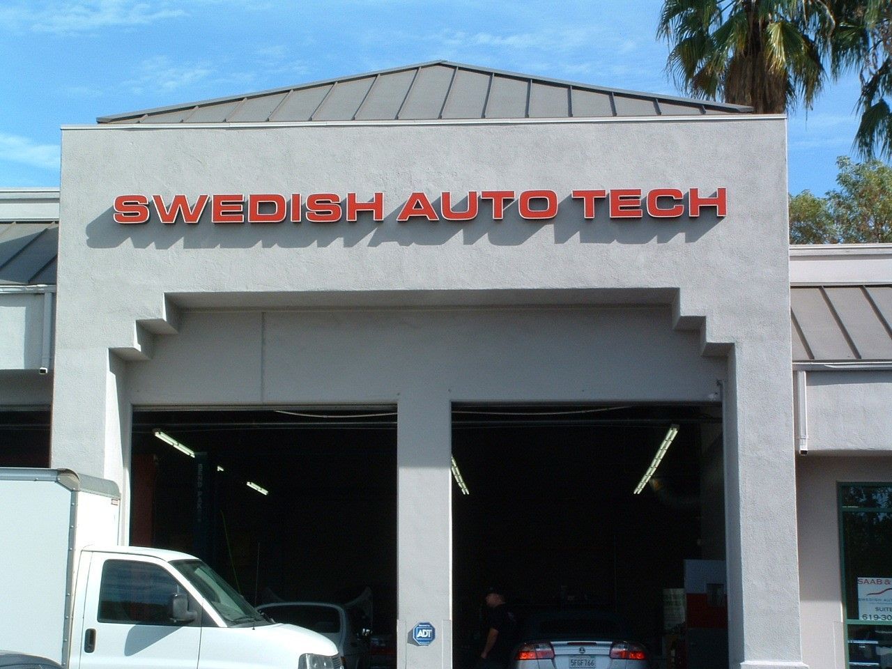 A white truck is parked in front of swedish auto tech