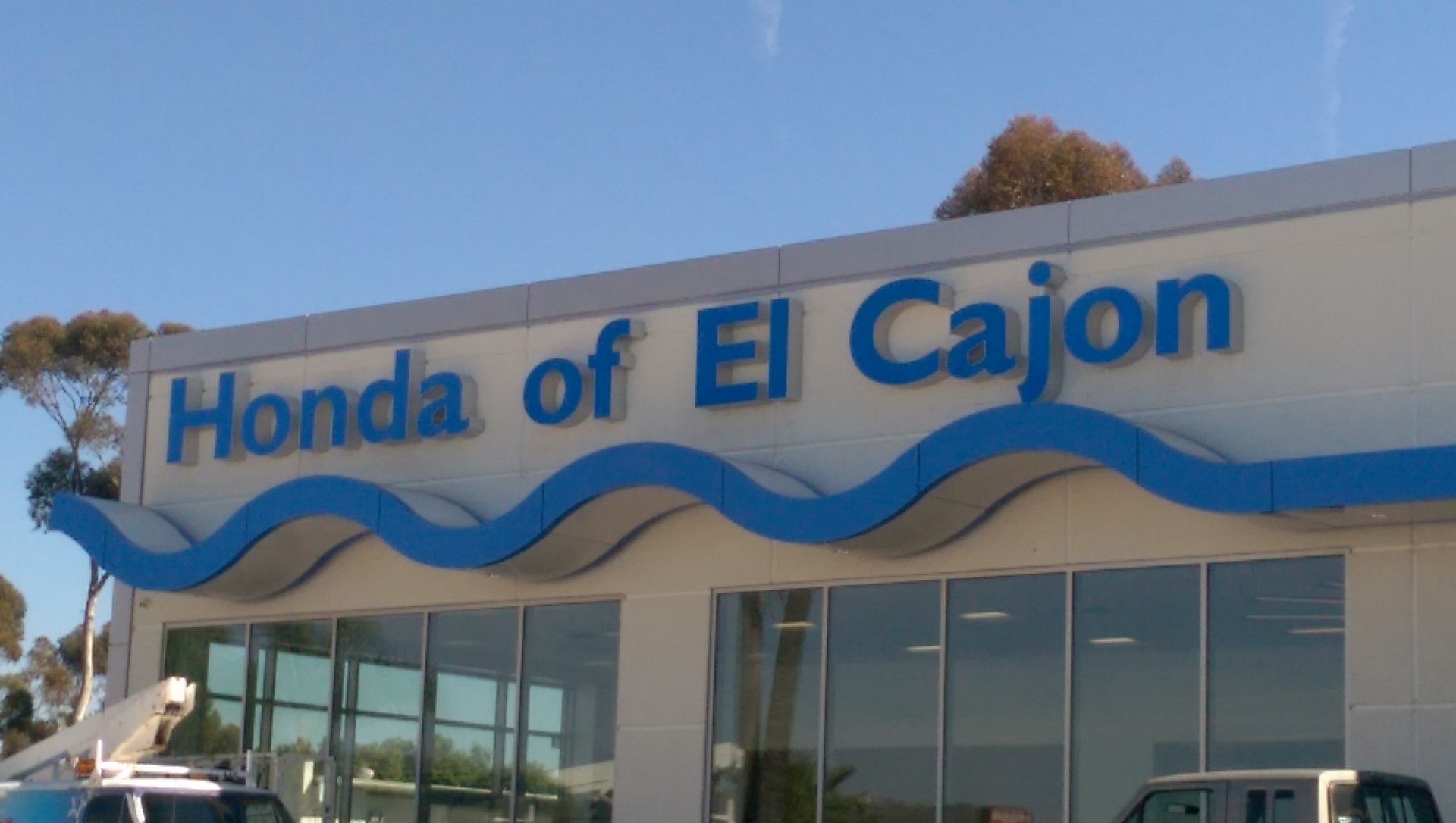 A honda of el cajon dealership with a car parked in front of it