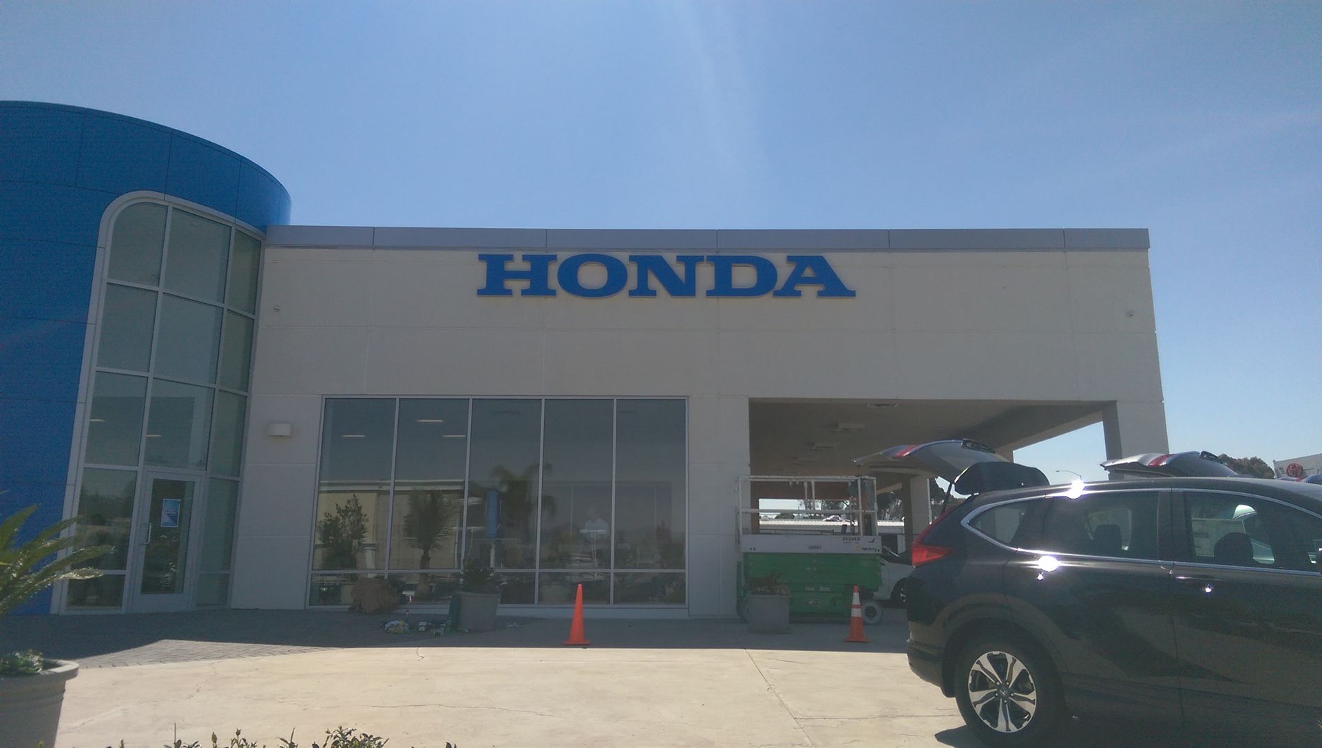 A car is parked in front of a honda dealership.