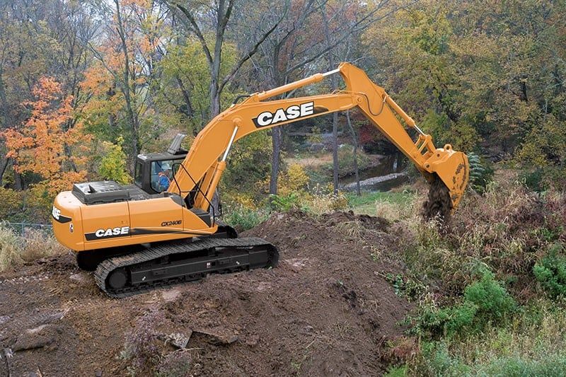A Northport excavating contractor using an excavator to move dirt in a field.