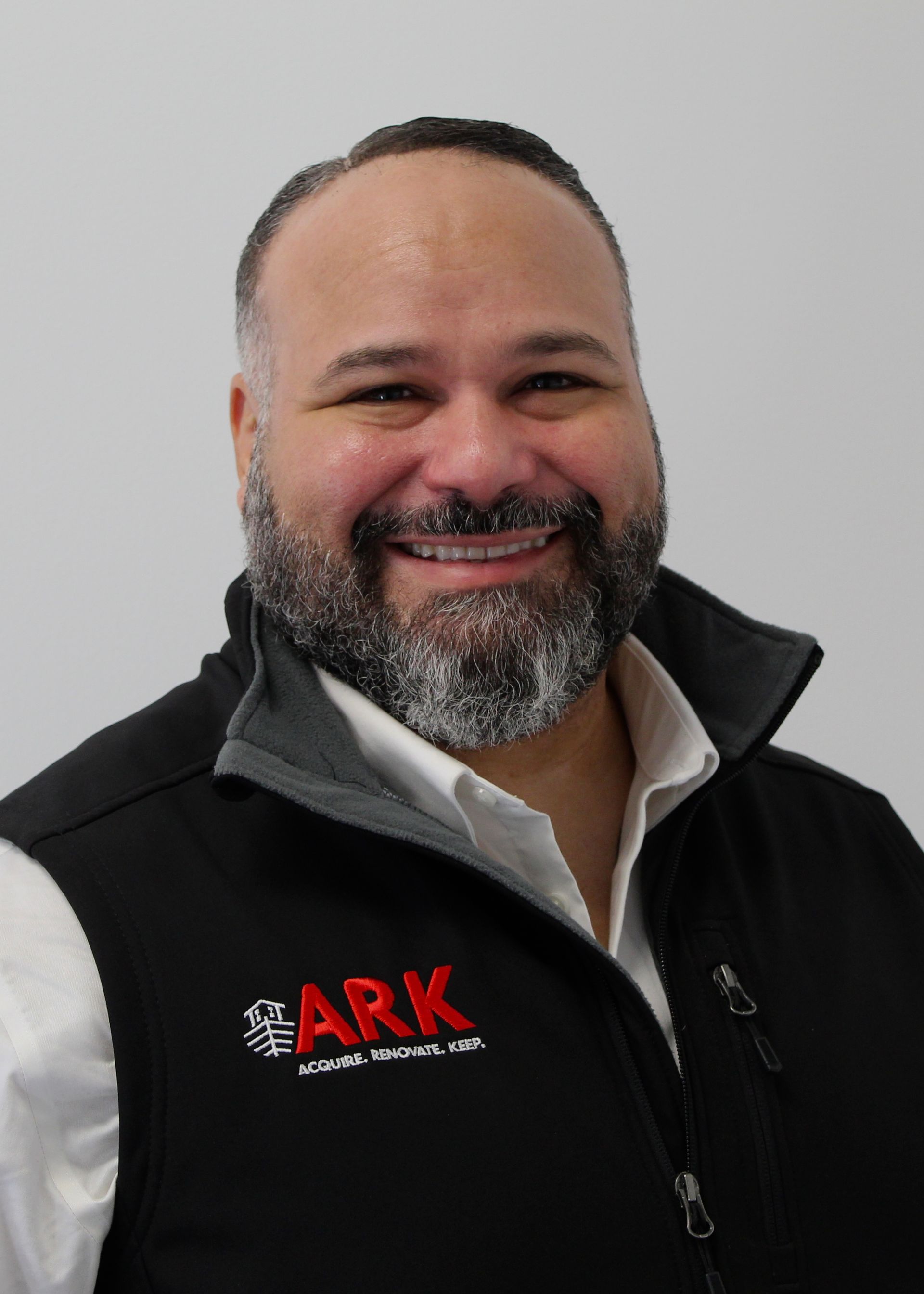 Man with beard wearing black vest with 