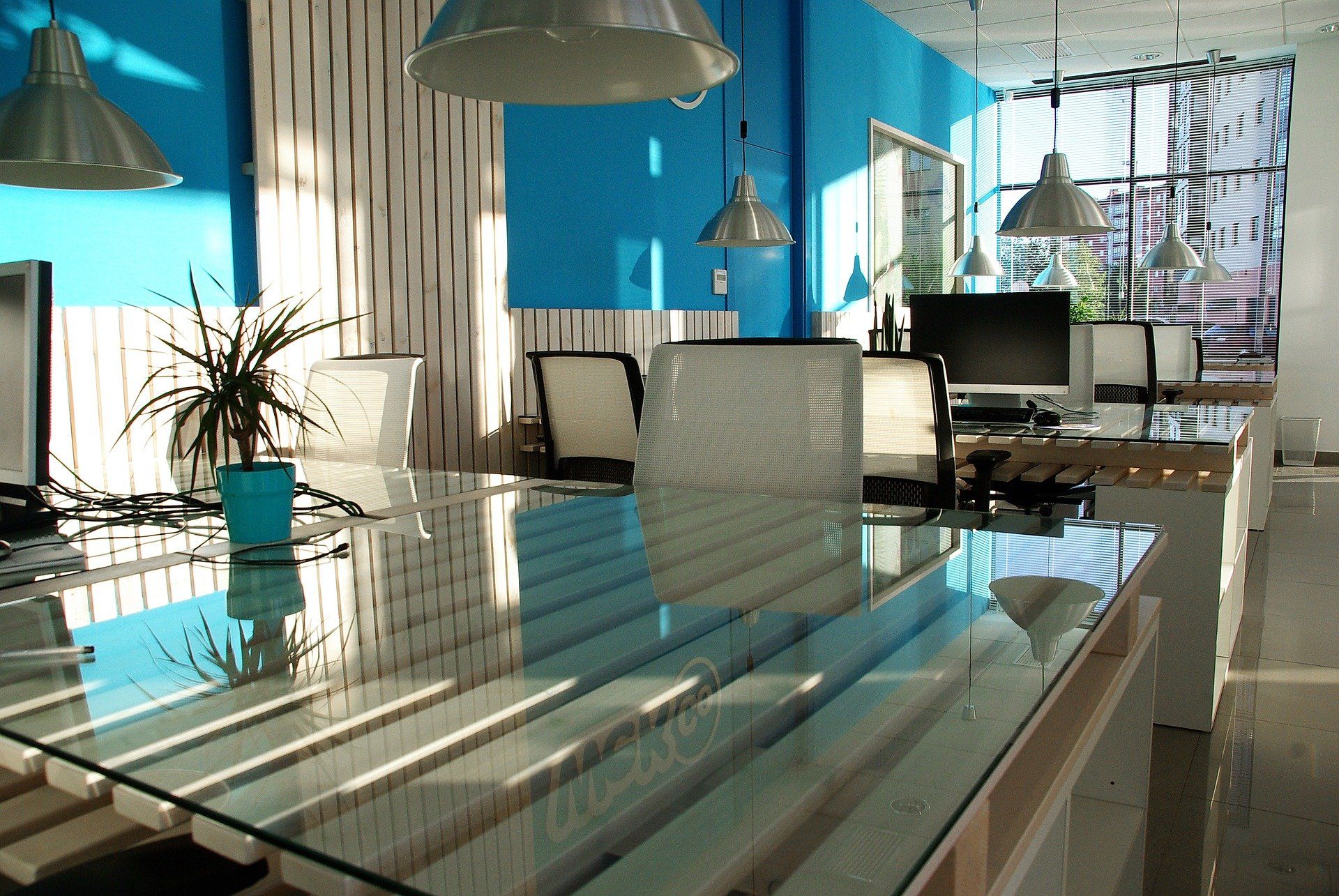 An office with blue walls and a glass table