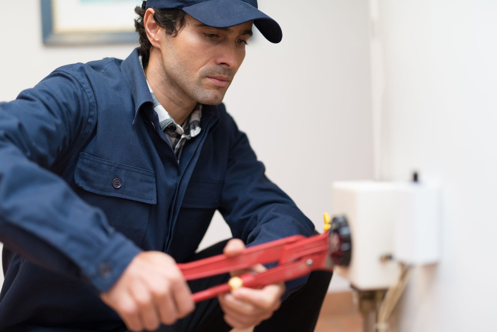 A person using a tool to cut a hole | Water Heaters in Wichita, KS A person using a tool to cut a hole | Water Heaters in Wichita, KS