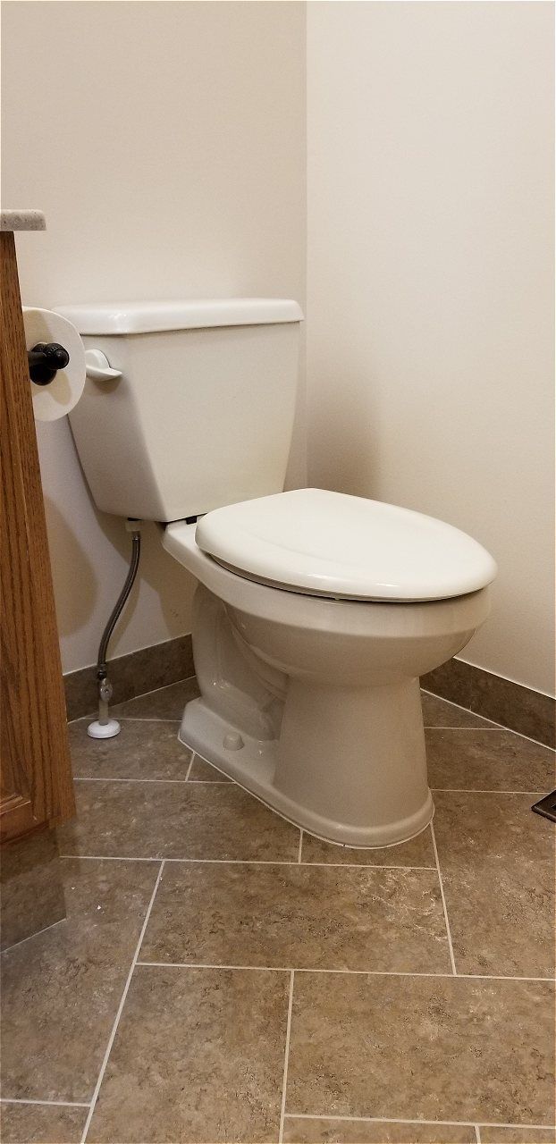 A Toilet Is Sitting On A Tiled Floor In A Bathroom | Wichita, KS | David Lies Plumbing