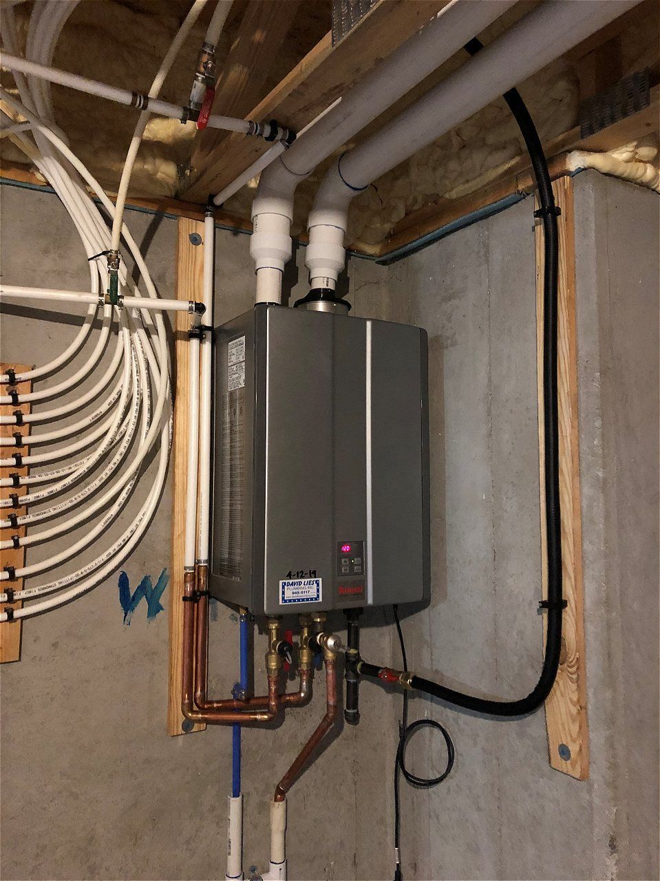 A Water Heater Is Hanging From The Ceiling In A Basement | Wichita, KS | David Lies Plumbing