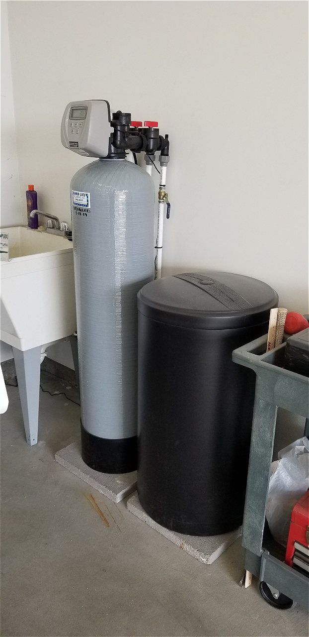 A Water Softener Is Sitting Next To A Sink In A Garage | Wichita, KS | David Lies Plumbing
