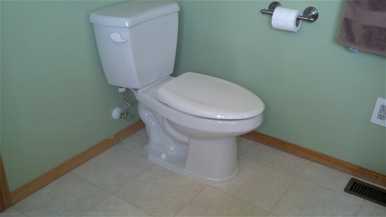 A Toilet In A Bathroom With A Paper Towel Holder | Wichita, KS | David Lies Plumbing