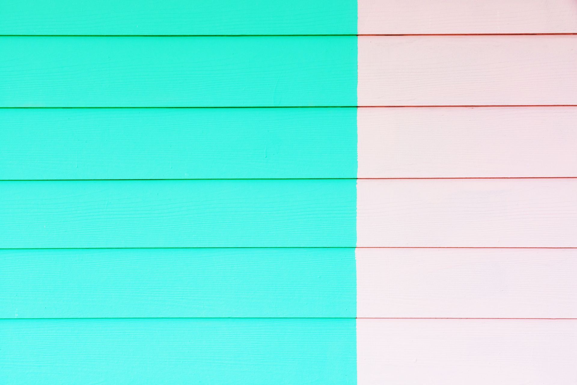 A close up of a green and pink wooden wall.