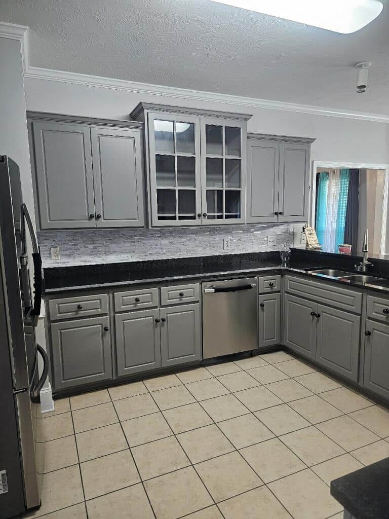 A kitchen with gray cabinets and stainless steel appliances