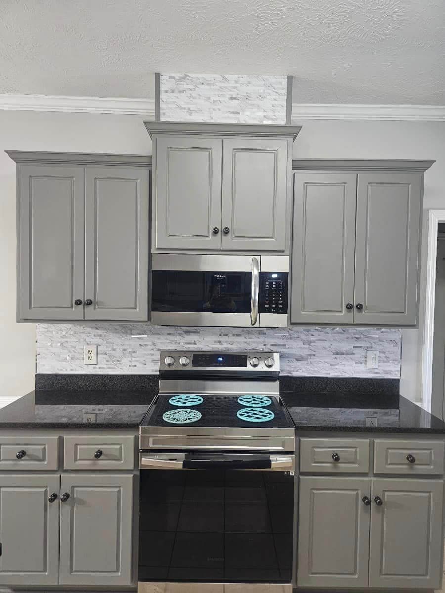 A kitchen with stainless steel appliances and gray cabinets