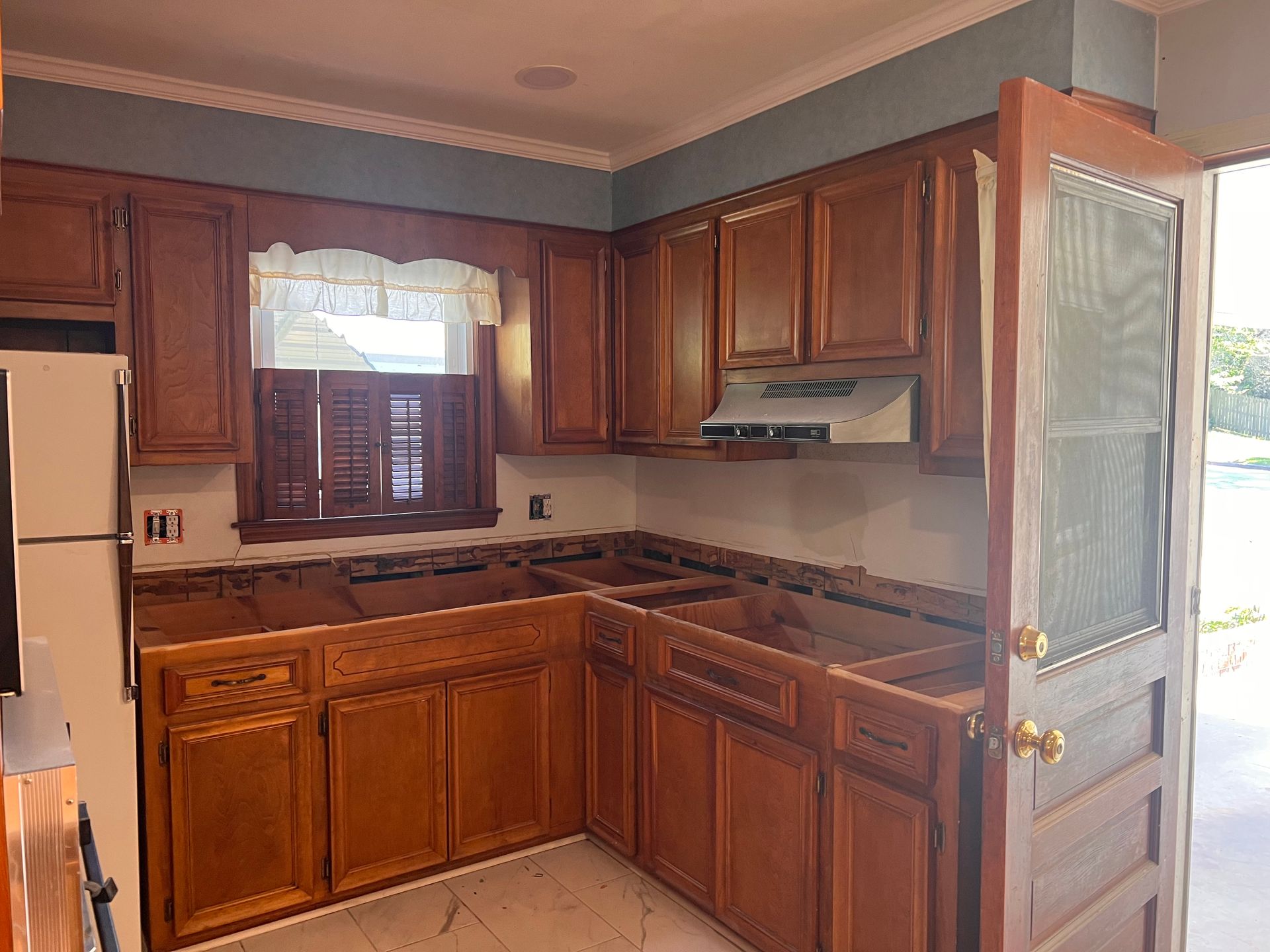 A kitchen with wooden cabinets and a white refrigerator