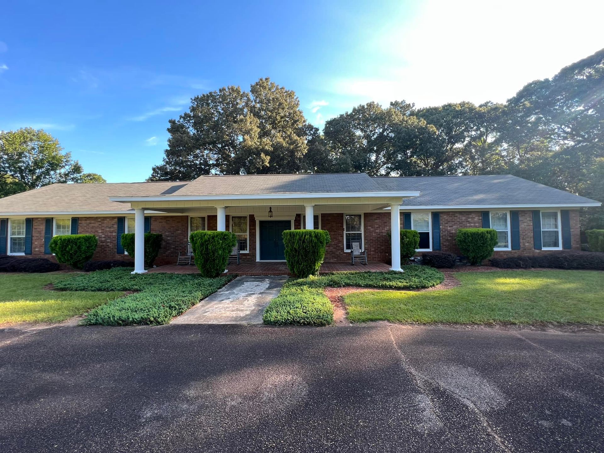 The front of a brick house with blue shutters