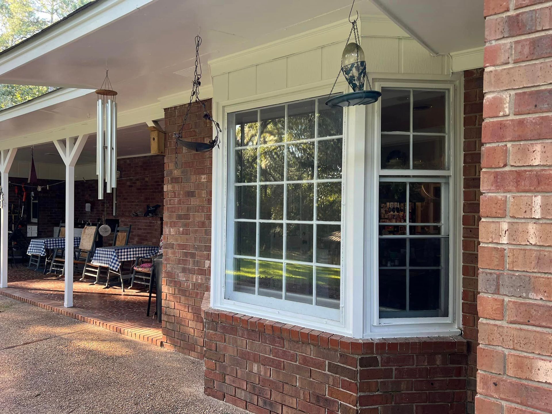 A brick house with a white window and a bird feeder