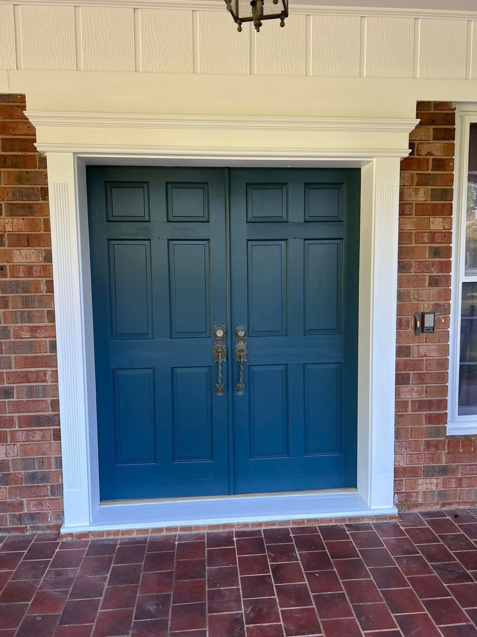 The front door of a brick house has been painted blue