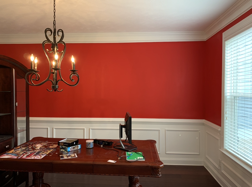 A dining room with red walls and a chandelier