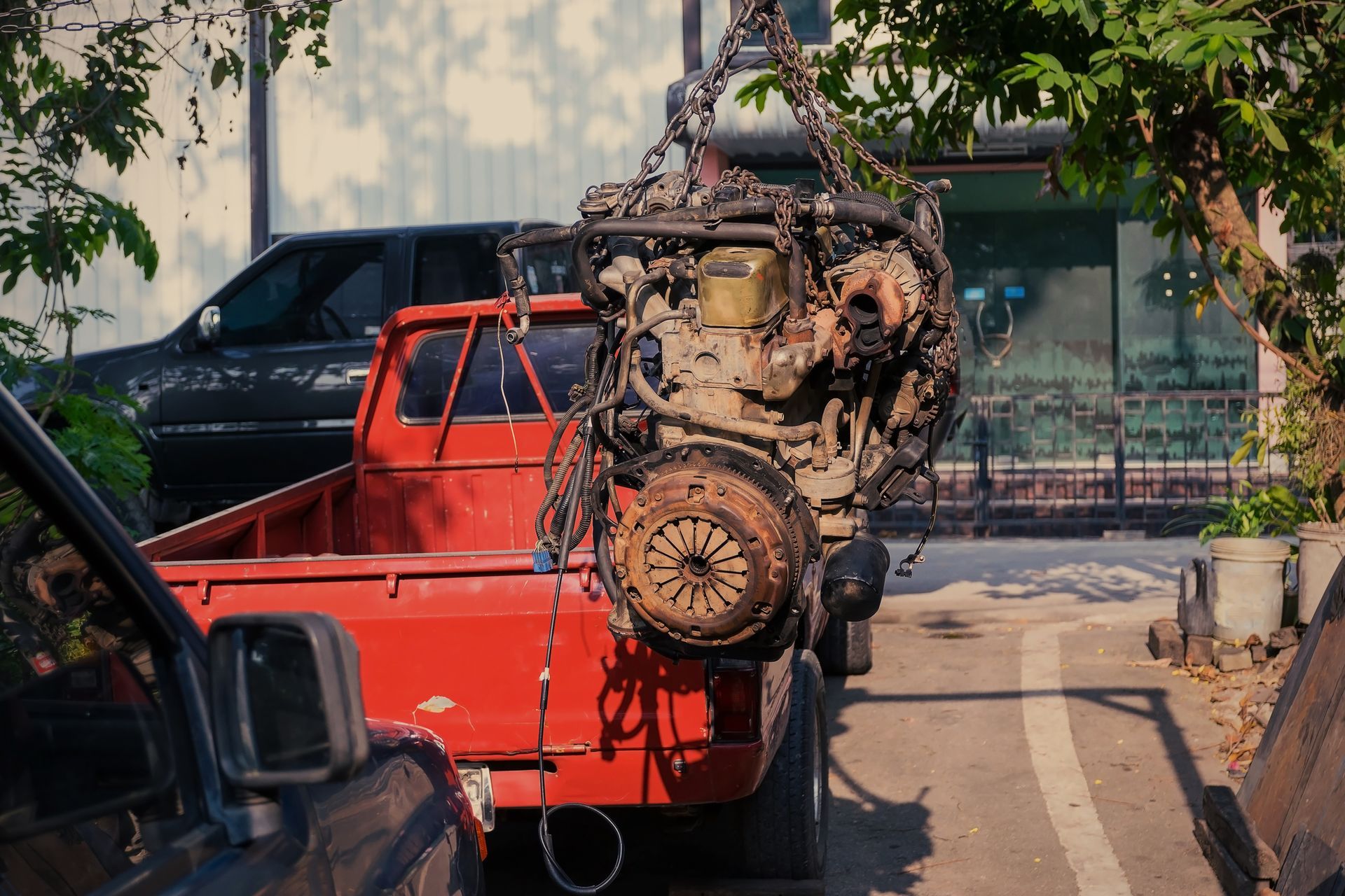 Old or used car engine hanging on the crane, showcasing reliable motor supply. 