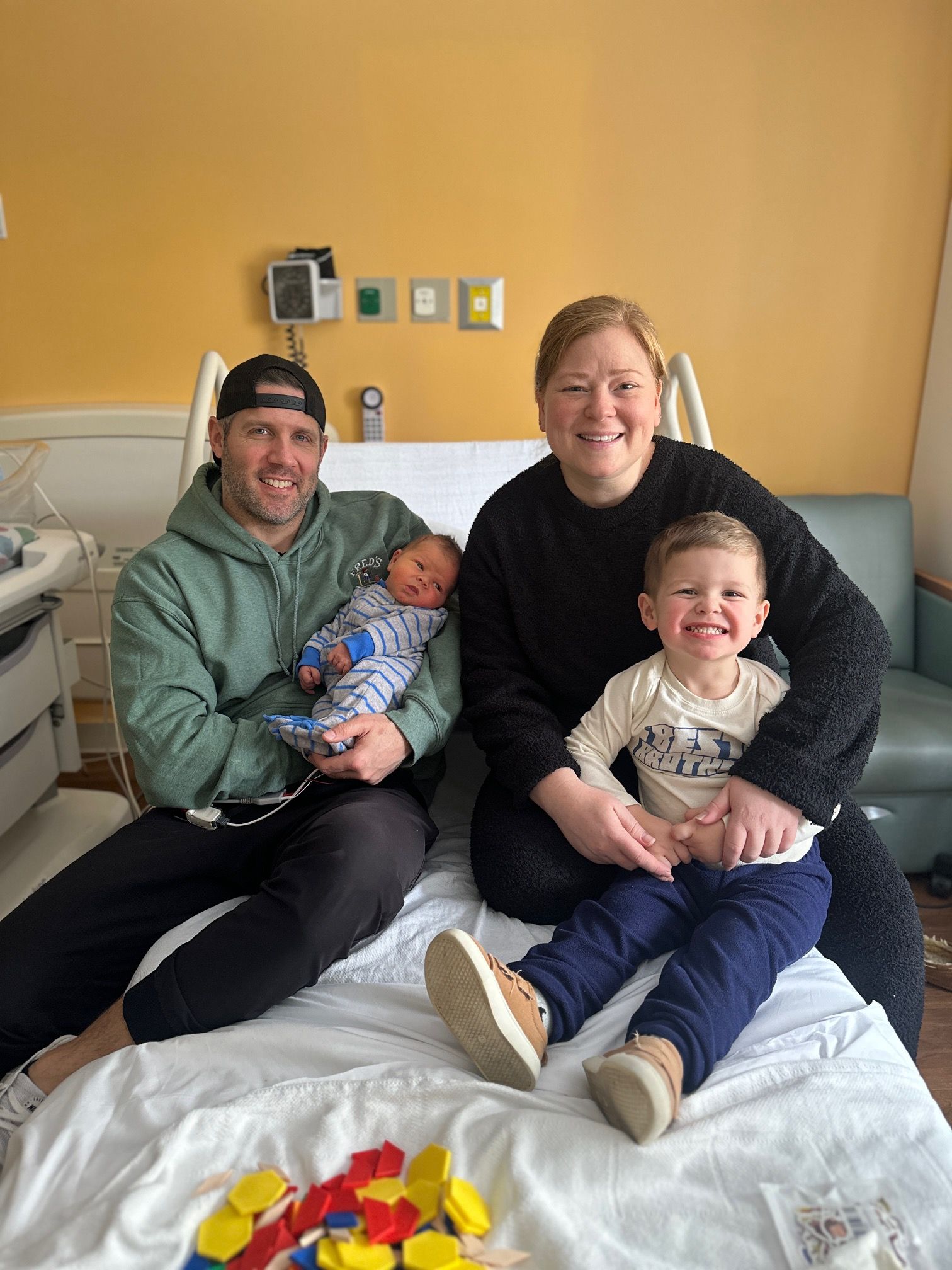 A man drinking water while standing next to a pink flamingo suitcase