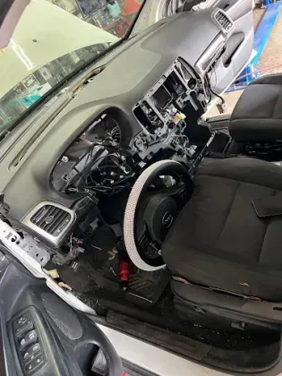 The interior of a car is being repaired in a garage.