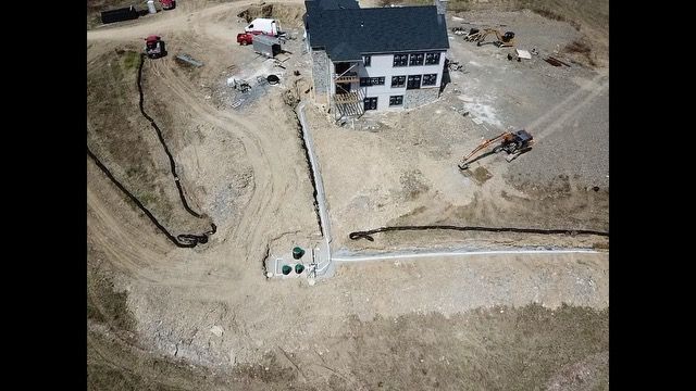 An aerial view of a house under construction in the middle of a dirt field.