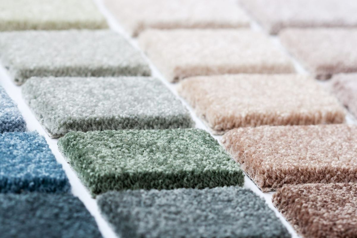 Carpet samples in various colors, including blue, green, beige, and brown.