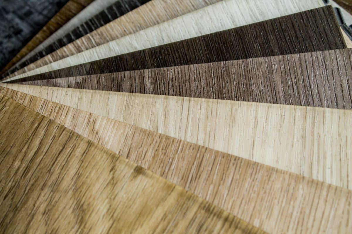 Wooden flooring samples in various shades, fanned out.