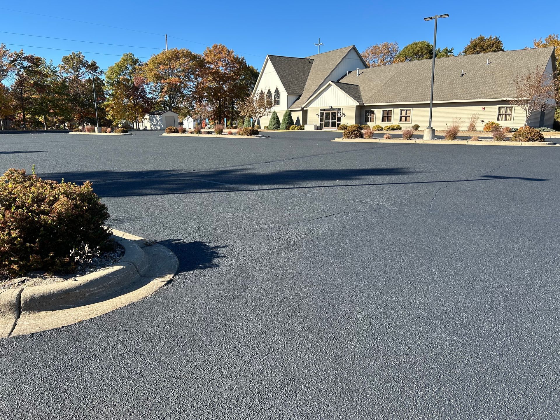 An empty parking lot with a house in the background