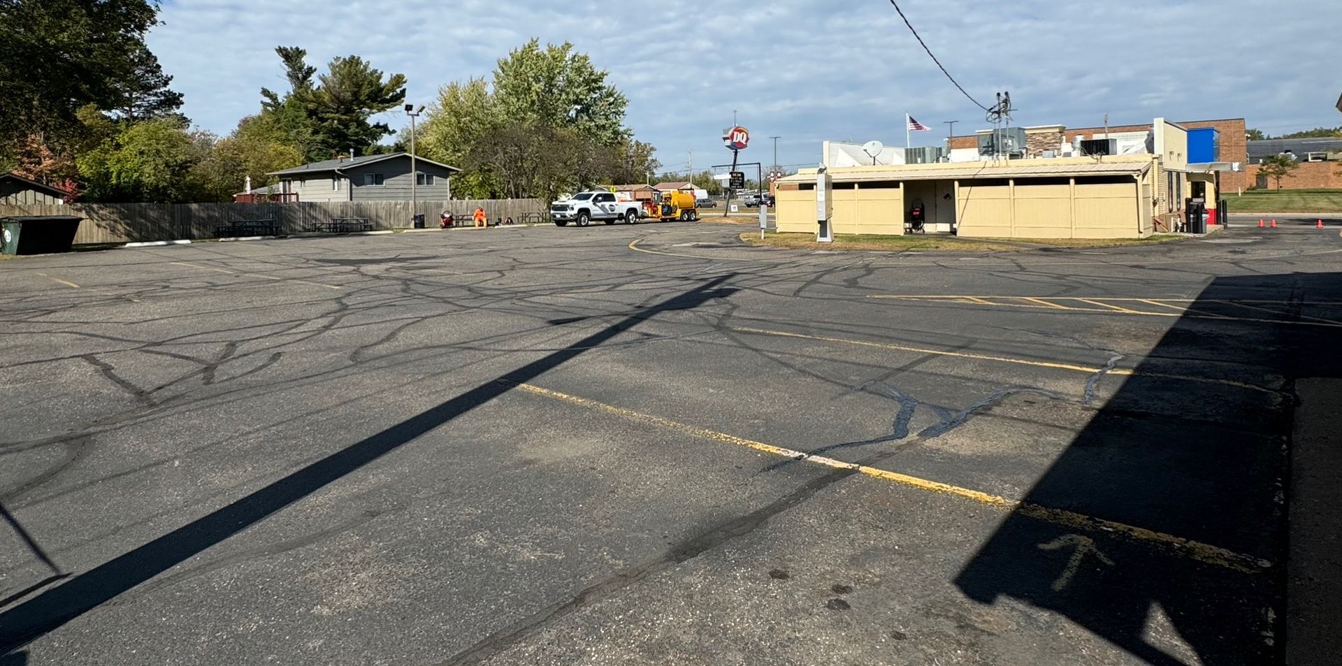 An empty parking lot with a yellow building in the background.