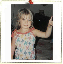 A little girl in a butterfly tank top is giving a peace sign