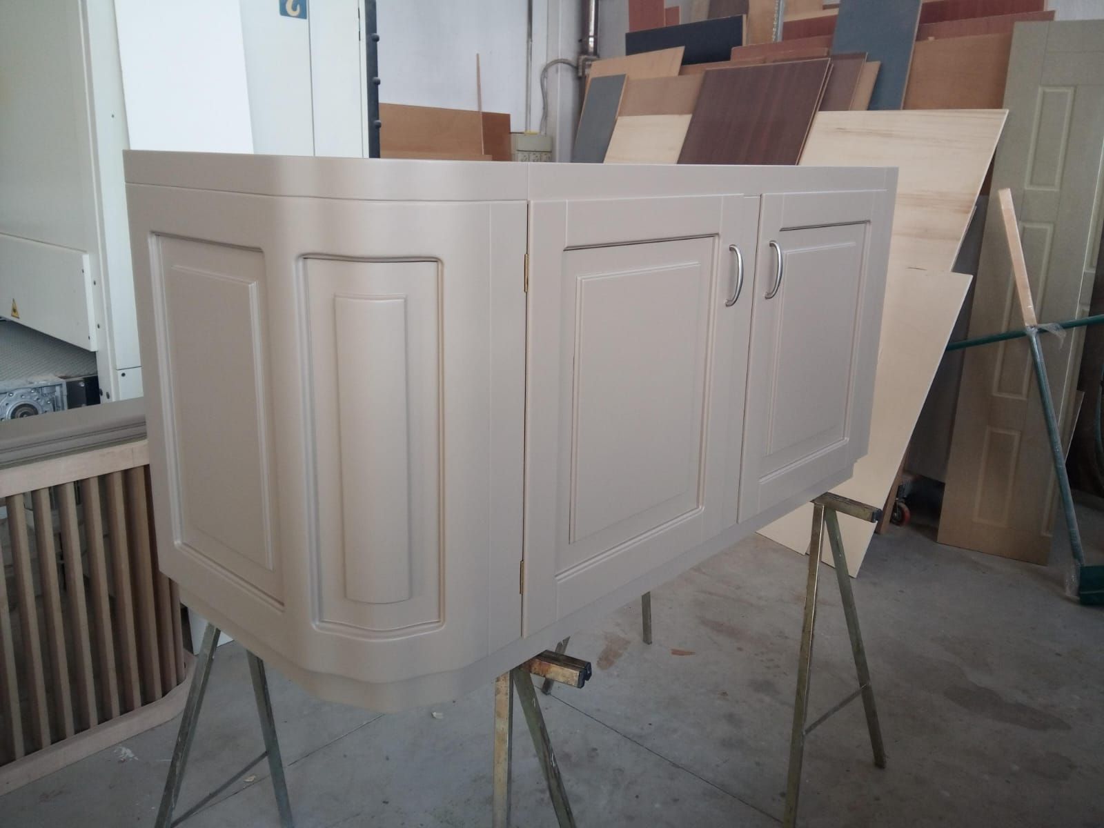 Cassettiera in legno con quattro cassetti, sormontata da una pila di scatole marroni, su uno sfondo blu.