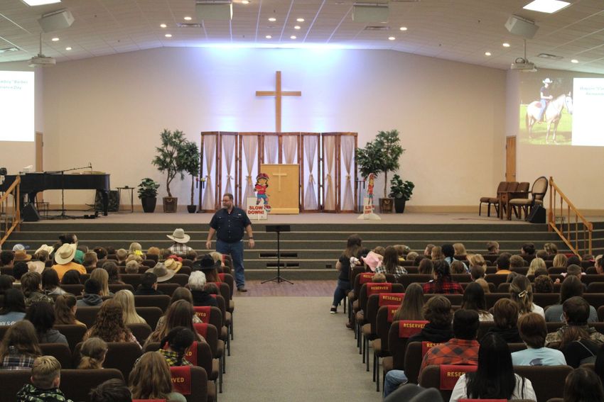 A man stands on a stage in front of a crowd in a church