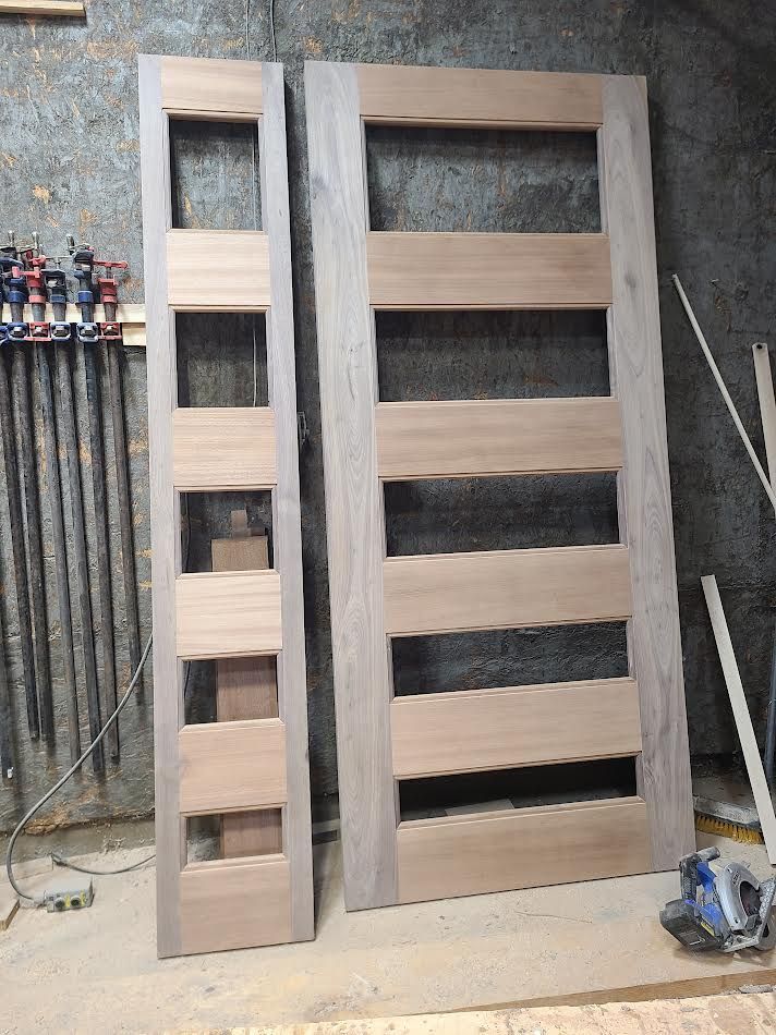 Two unfinished wooden doors, one tall and narrow, the other rectangular with horizontal slats.