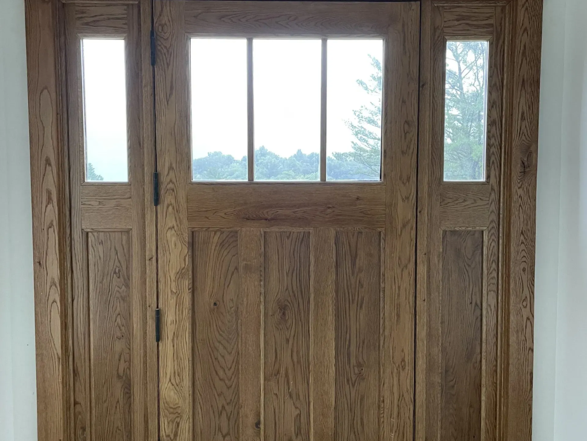 Wooden front door with sidelights, window in the door, oak grain.