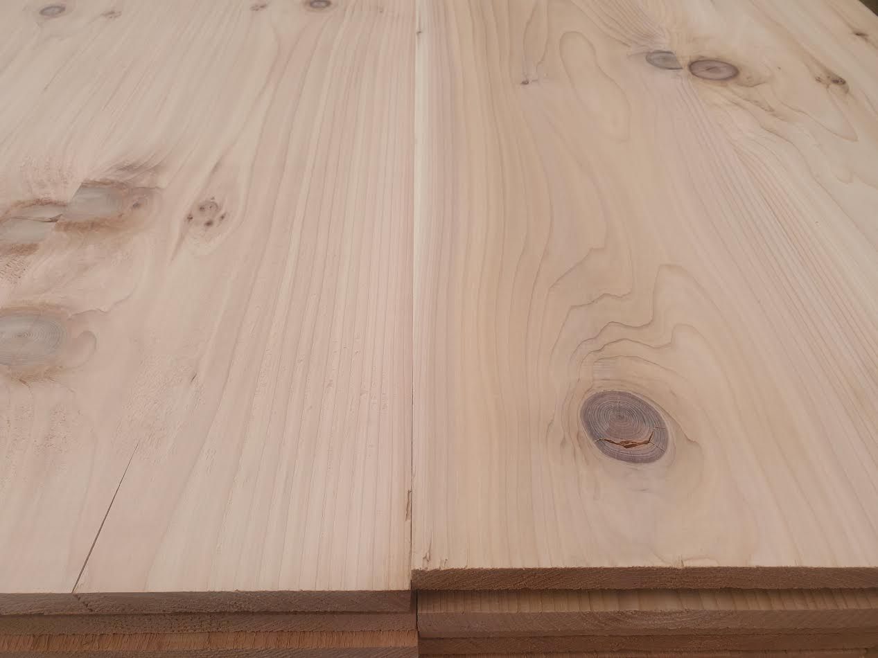 Light-colored wooden planks joined together. Visible knots and grain.